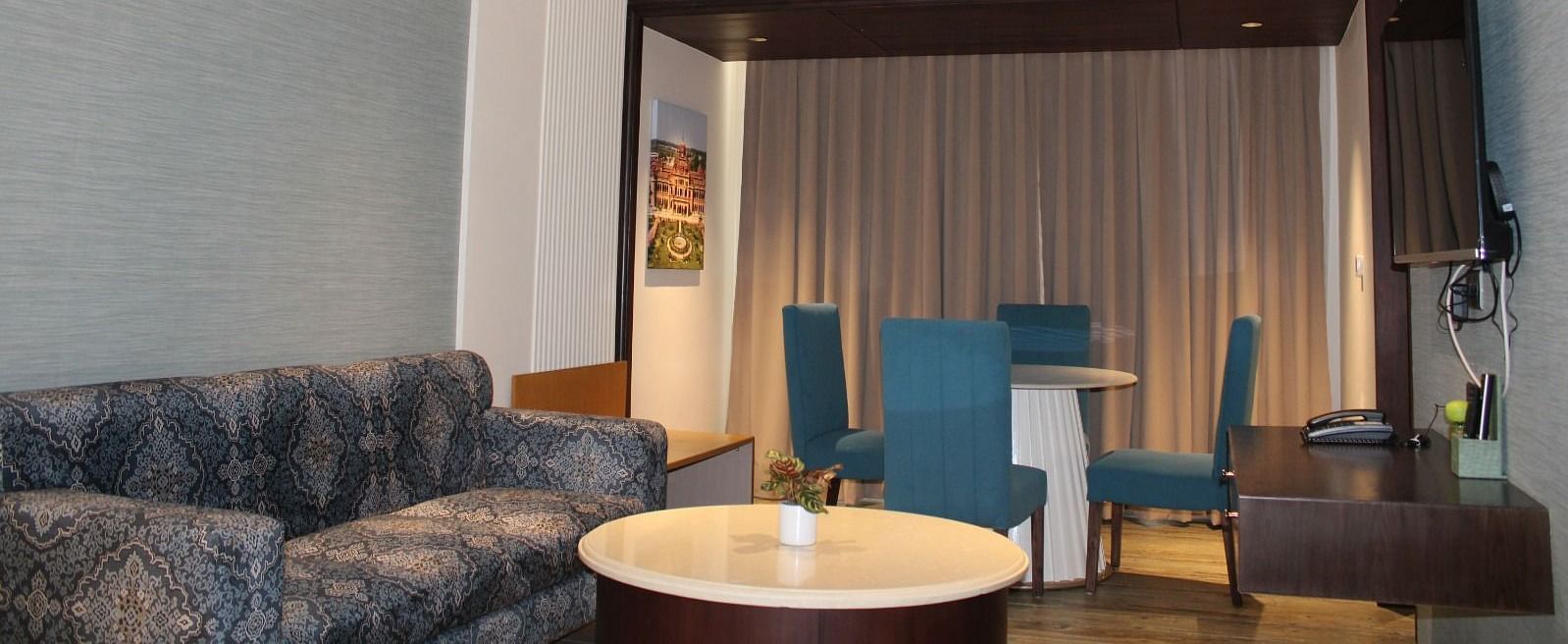 Suite living room with dining set and a sofa at BluSalzz Residence, Amritsar.